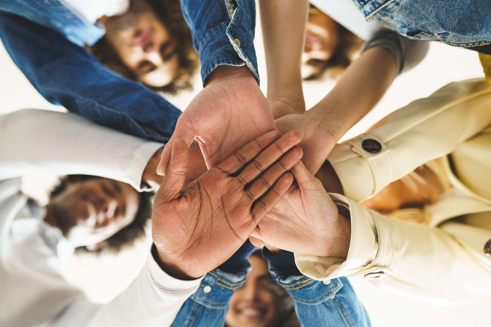 A group of people joins their hands together while smiling at the camera. This could symbolize the support an online therapist in Oregon can offer with learning thankfulness. Contact an Oregon online therapist or search “online therapy oregon” today to learn more.