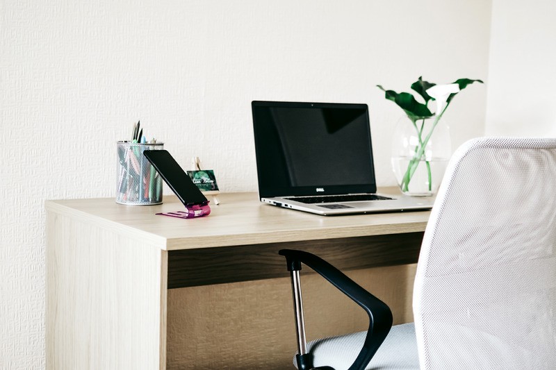 Chair and desk with computer and phone set up for working from home during COVID. Online Therapy in Oregon can help with stress and anxiety in relationships.