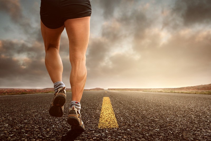 Legs of man running down a street. Staying active during stay at home order at the advice of his Tigard, OR therapist.