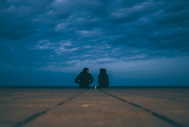Photo of two people sitting in the dark. For mental health help after covid-19 please contact our counseling clinic in Tigard, OR.