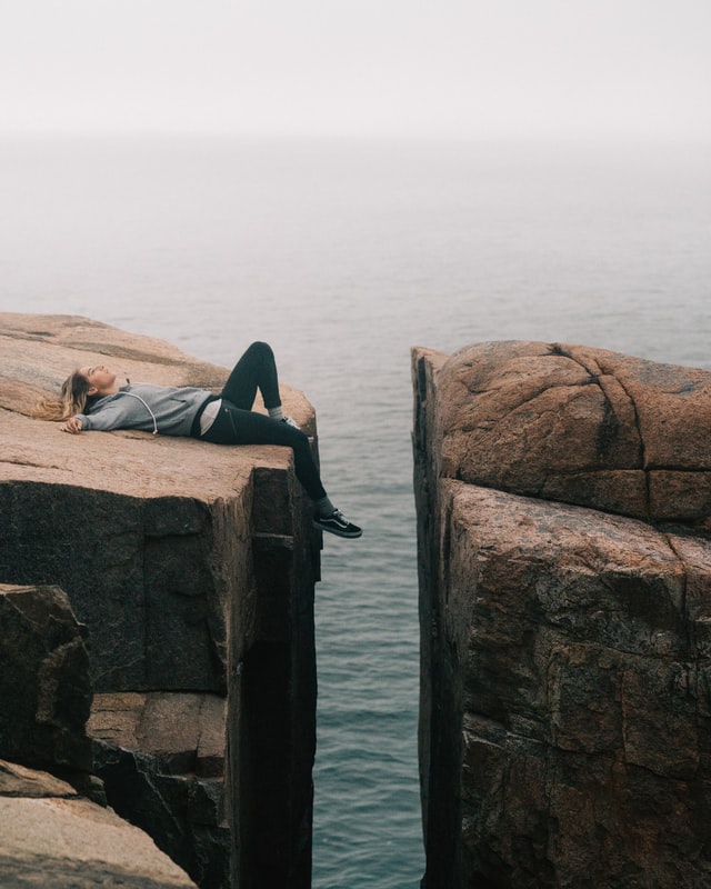 female athlete tired exhausted from running lying on rock