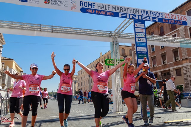 runners celebrating together at finish line of race holding hands. As you re-engage in life, reach out and work with one of our Tigard, OR therapists if you find yourself struggling.