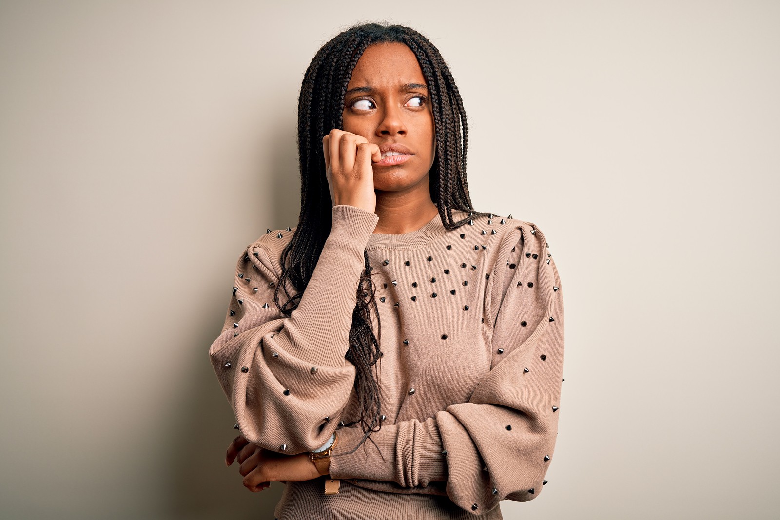 Black woman bites her nails looking anxious. She learns about seeing healthy boundaries in online therapy in Oregon with an online therapist from Discover Counseling in Tigard, OR