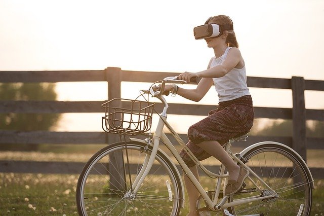 Woman riding a bike while wearing a VR headset. You can get help with anxiety therapy, depression treatment, codependency counseling and more with online therapy in oregon. Learn more from a Tigard, OR therapist here. 