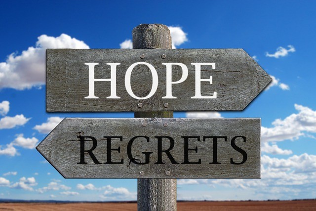 Sign that says "Hope" facing the right and "Regrets" facing the left with blue sky and clouds in the background. Opening up in therapy can be vulnerable. Get help from a Tigard, OR counselor with online therapy in Oregon here.