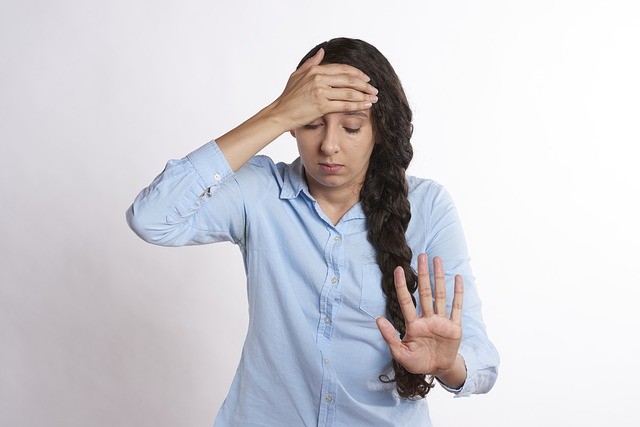 woman with her hand on her head saying stop to represent not letting emotions dictate your actions. Learn more from an online therapist who offers online therapy for anxiety in Oregon