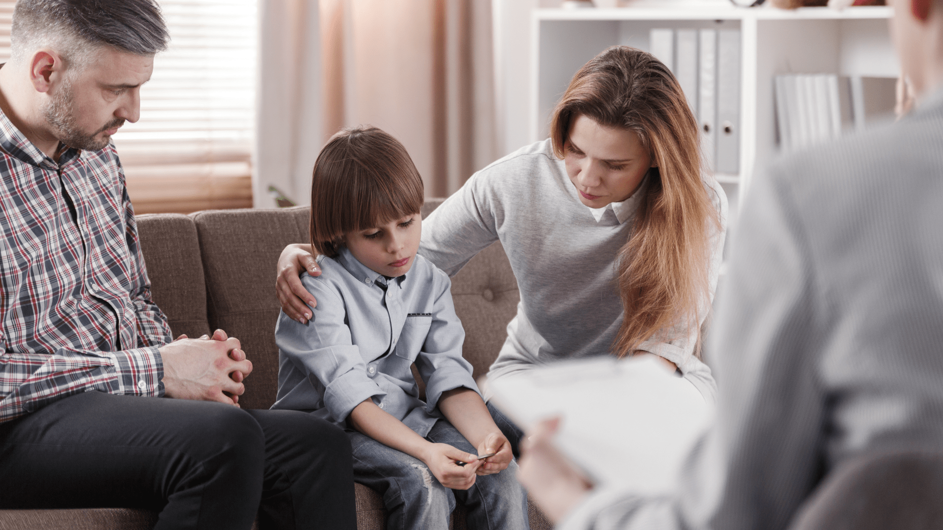 Family looking at upset kiddo. Child counseling in Tigard, OR can help your family thrive. Talk with a skilled child therapist with online therapy in Oregon here!