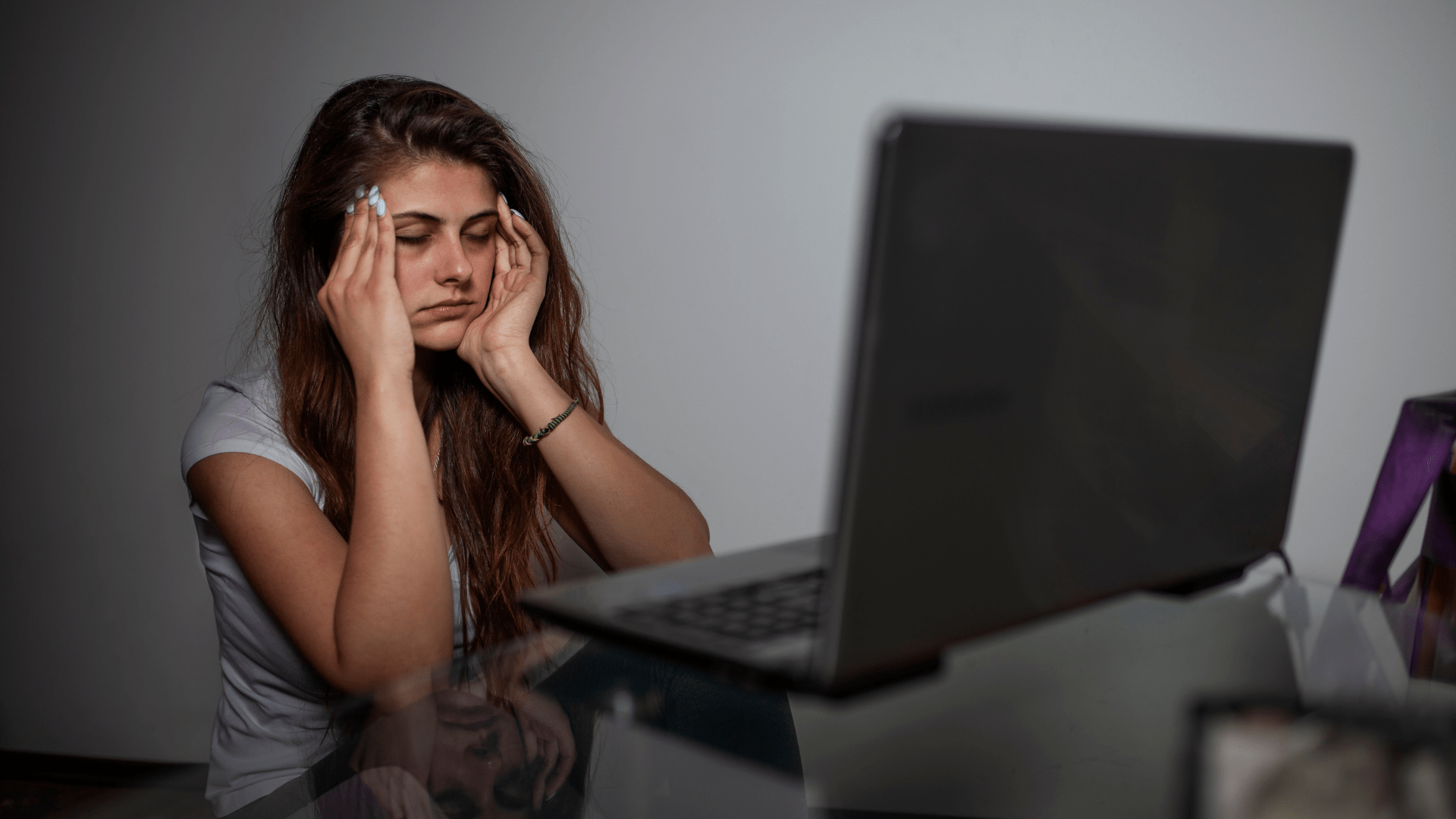 Image of a woman sitting at her computer with her hands on her temples looking stressed. Whether you are looking for therapy for relationship issues or just to make time for your relationship we can help. Contact Discover Counseling to start therapy in Tigard, OR 97223.