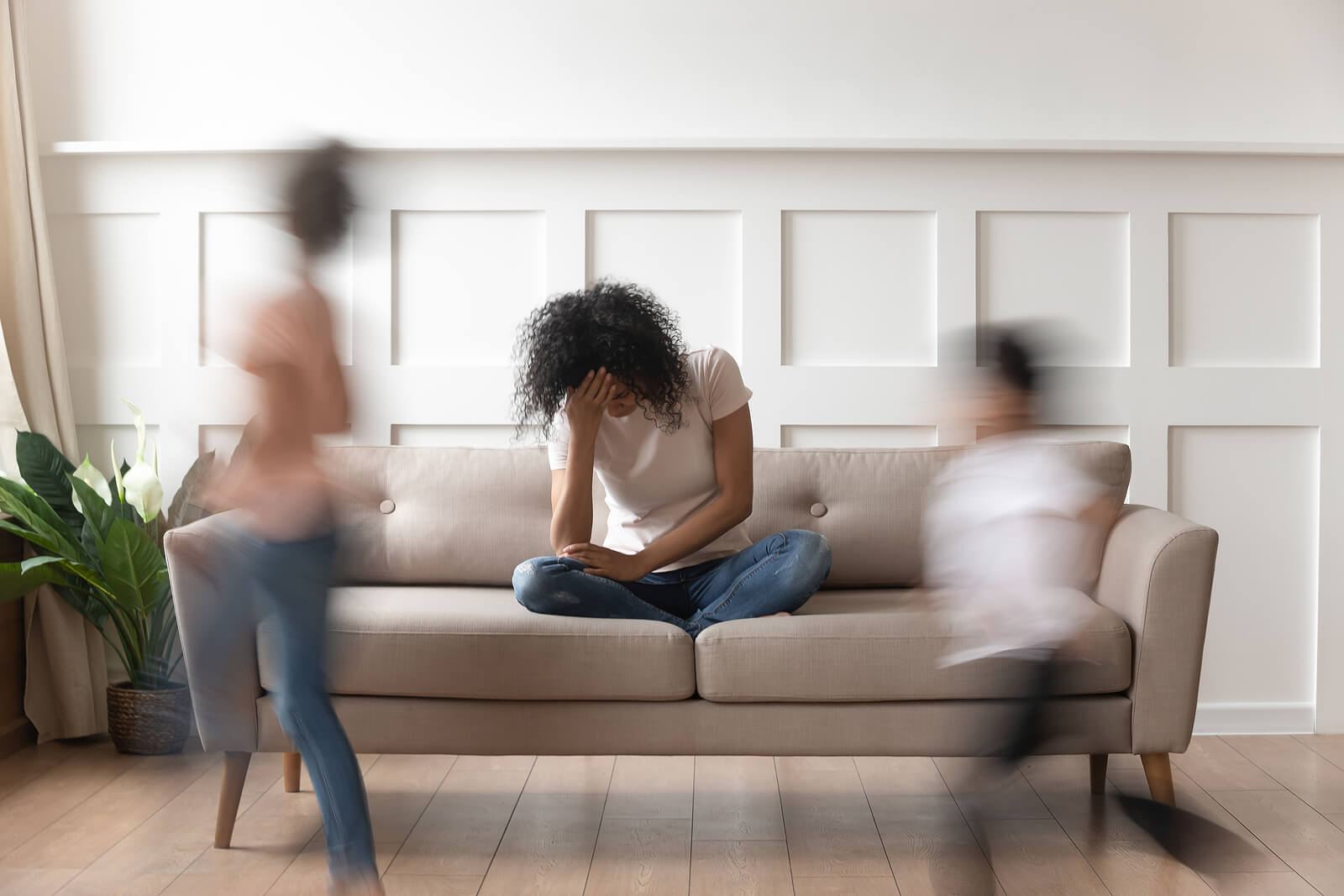 Image of a stressed out mom with 2 kids running around. Our online therapist in Oregon can help you find your balance. In online therapy in Oregon you can address your perfectionism. Create a life that you serves your season of life in online counseling in Oregon.