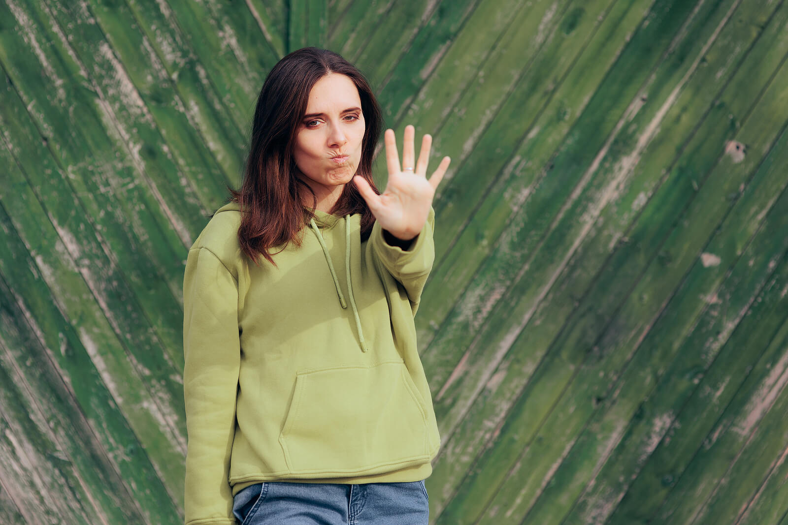 Woman standing with her hand out representing someone setting boundaries to improve their mental health. You too can learn to set healthy boundaries with online therapy in Oregon. Learn more here.
