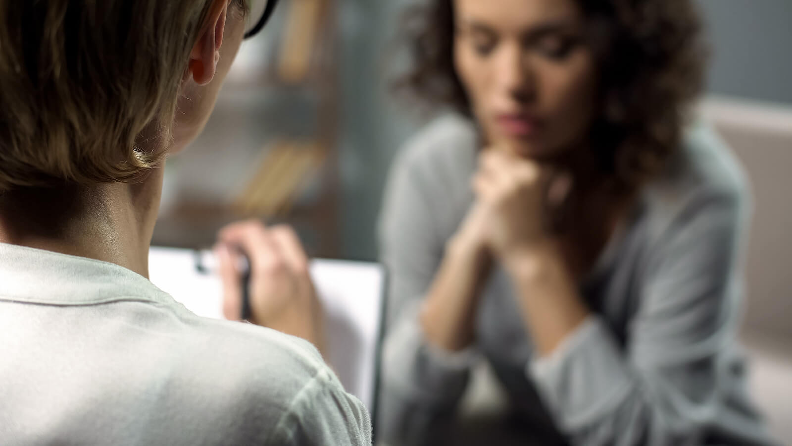 A close up of a person with a clipboard writing something while listening to a woman sitting across from her. This could represent the support a therapist for life transitions in Tigard, OR can offer. Learn more about life transition therapy today for more support.
