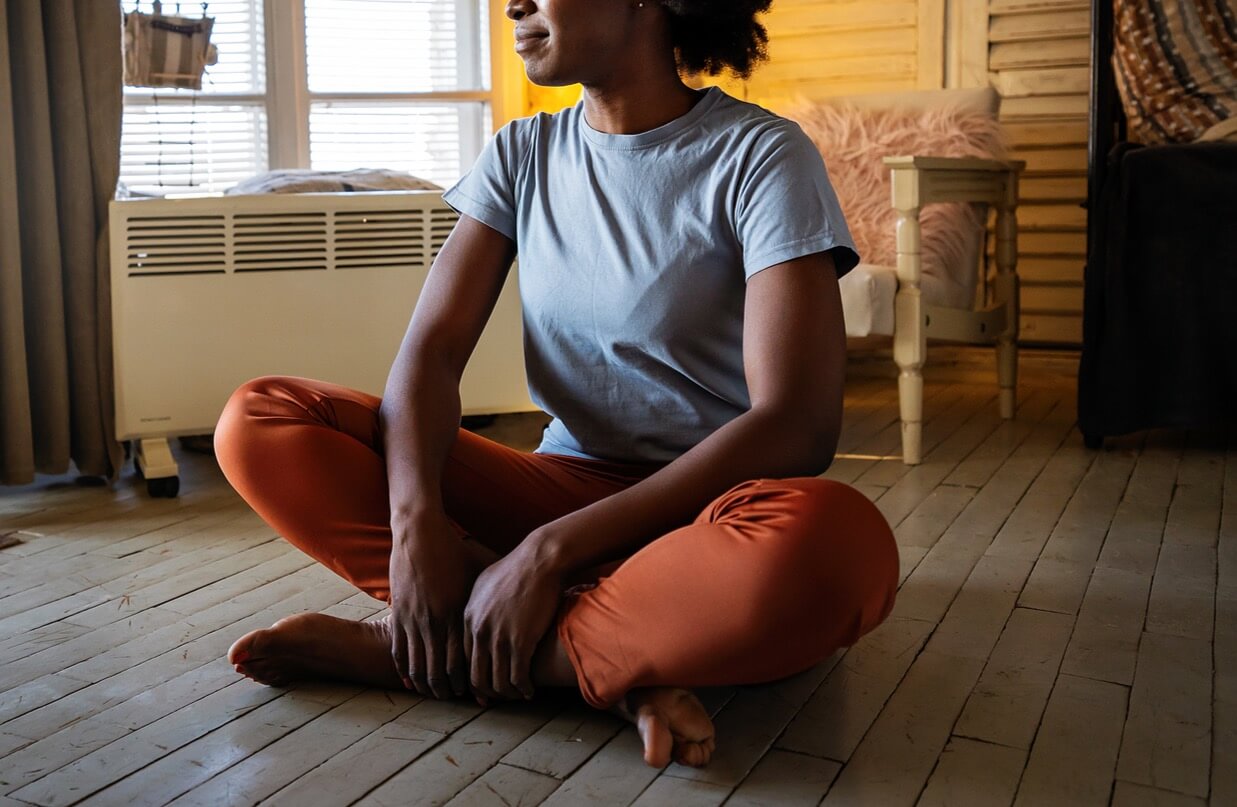 sitting | christian therapist in tigard, or | christian counseling in tigard, or | online counseling in oregon | 97223 A woman sits on the floor while looking around her room. This could represent mindfulness techniques cultivated by working with a Christian therapist in Tigard, OR. Learn more about therapy in Tigard, OR and the benefits online counseling in Oregon can offer today.