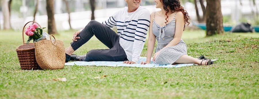A couple smiles at one another while sitting on a picnic blanket in a park. Learn how relationship therapy in Tigard, OR can support the bond between you and your partner. Search “couples counseling Tigard, OR” to learn more today.
