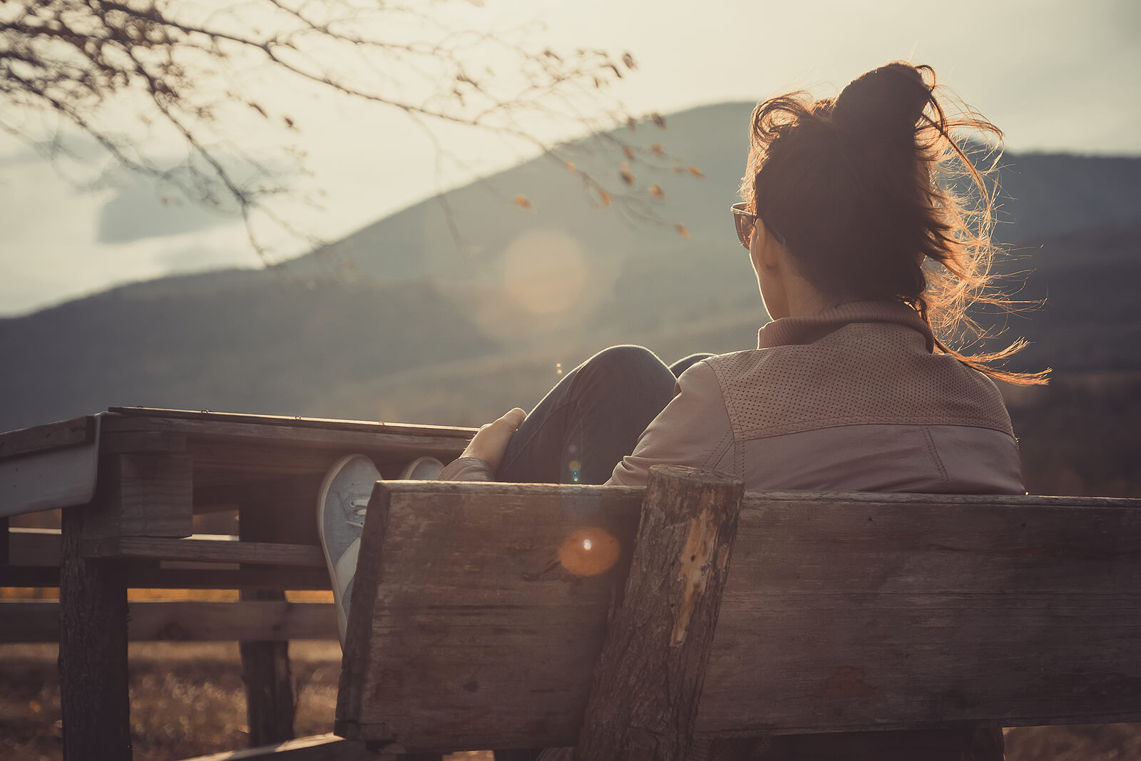 A woman sits on a park bench looking out at a landscape as the sun sets. This could symbolize the internal struggles overcome with the help of anxiety counseling in Tigard, OR. Learn more about social anxiety in Tigard, OR and other services by searching “anxiety counselor Tigard” today.
