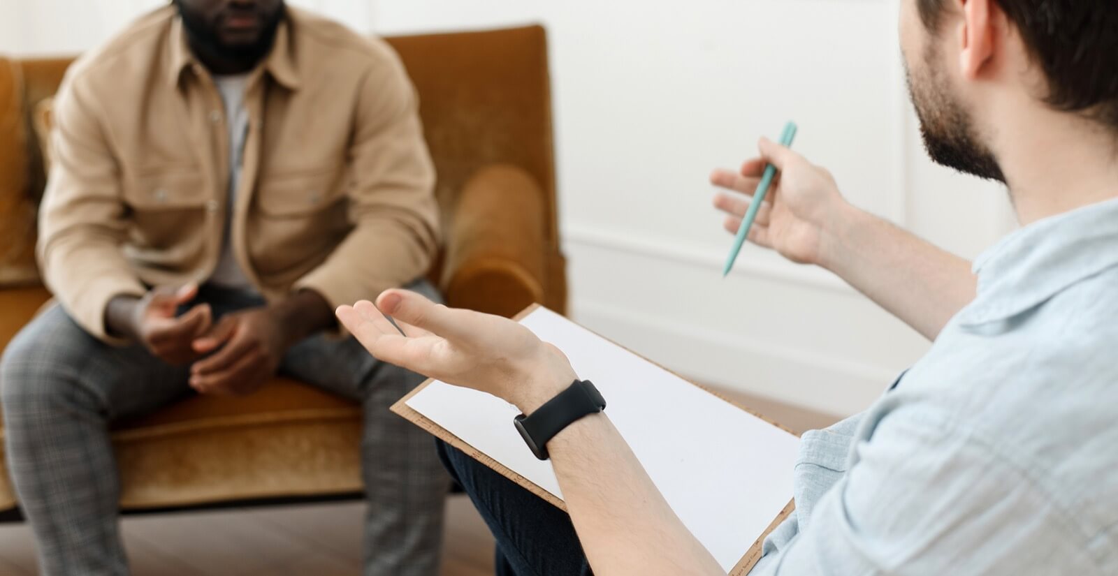 gesturing | major life changes in tigard, or | life transition counseling | online therapist in oregon | 97223 A man with a clipboard gestures with a clipboard while sitting across from someone. Learn how an online therapist in Oregon can offer support with major life changes in Tigard, OR by searching for life transition counseling and other services today.