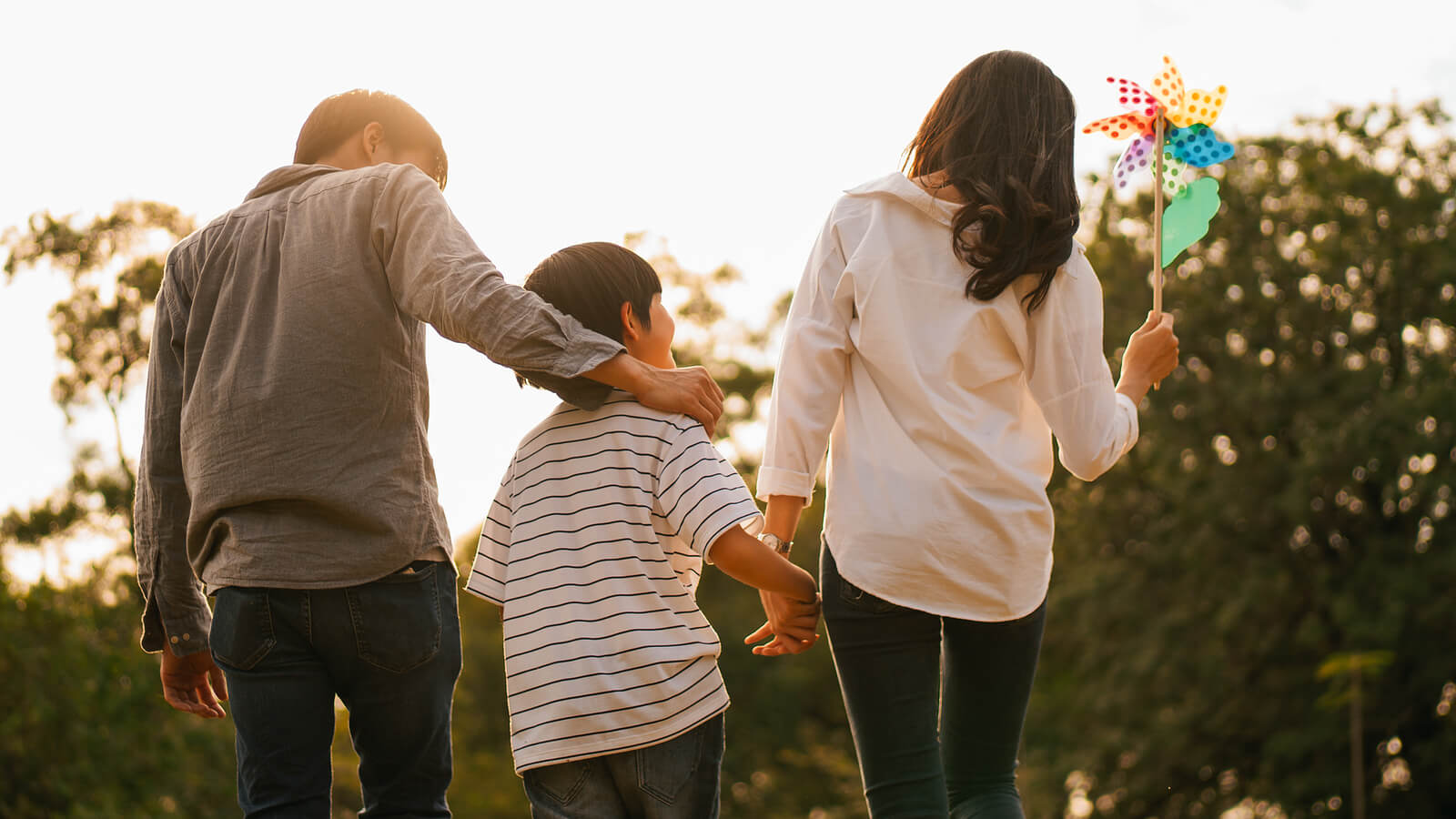 walking family | child therapist in tigard, or | child counseling in tigard, or | online therapist in oregon | 97223 | 97224 | 97281 A family of three walks together with a mother holding a pinwheel. This could represent the support familys can offer in nurturing young minds. Learn how a child therapist in Tigard, OR can help by searching for child counseling in Tigard, OR, or child therapist near me today.