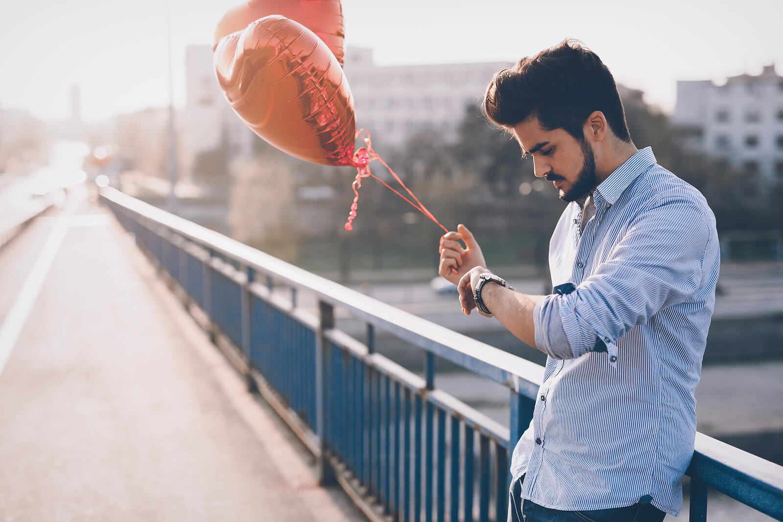 man waiting for date | codependency therapist in tigard, or | online therapist in oregon | codependency therapy | 97223 | 97224 | 97281 A man holds heart balloons while checking their watch. This could represent the stress of dating that an online therapist in Oregon can help you cope with. Learn more about online therapy for codependency and how you can recover via anxiety therapy in Tigard, OR.