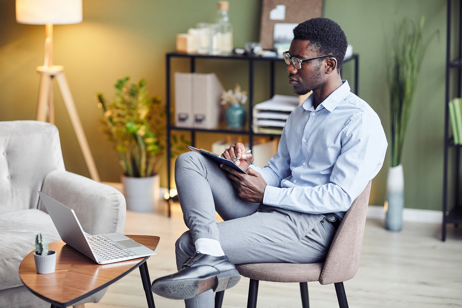 A black man takes notes while listening to something on their laptop. This could represent the benefits of online counseling in Oregon that an online therapist in Oregon can offer. Learn more about online therapy for codependency and other services today.

