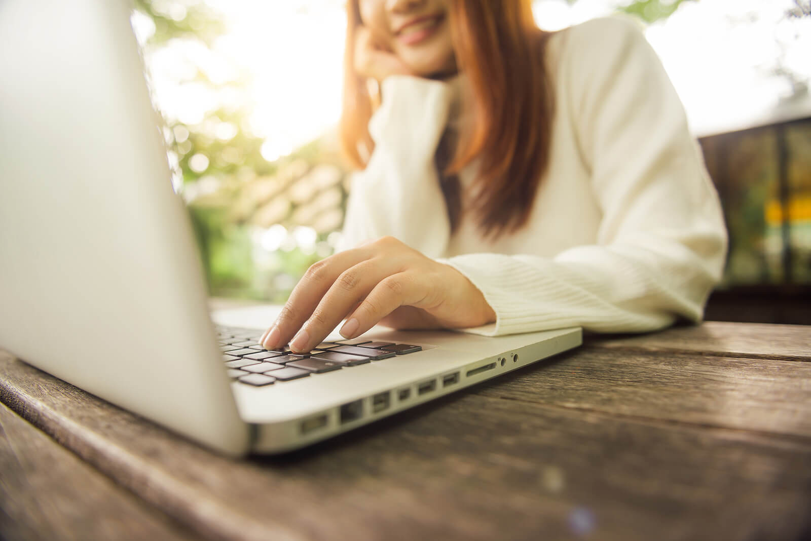 A close up of a woman typing on a laptop with her hand while smiling. Learn more about online counseling in Oregon and how remote support can offer help with addressing mental health concerns. Search for Oregon online therapist to learn more today.
