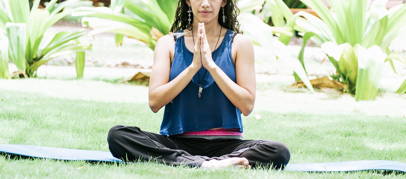 A woman outside on a yoga mat while sitting with her hands together. This could represent a coping technique that an anxiety therapist in Tigard, OR can help you practice. Search for "anxiety counselor tigard" to learn more about counseling for anxiety Tigard, OR today.