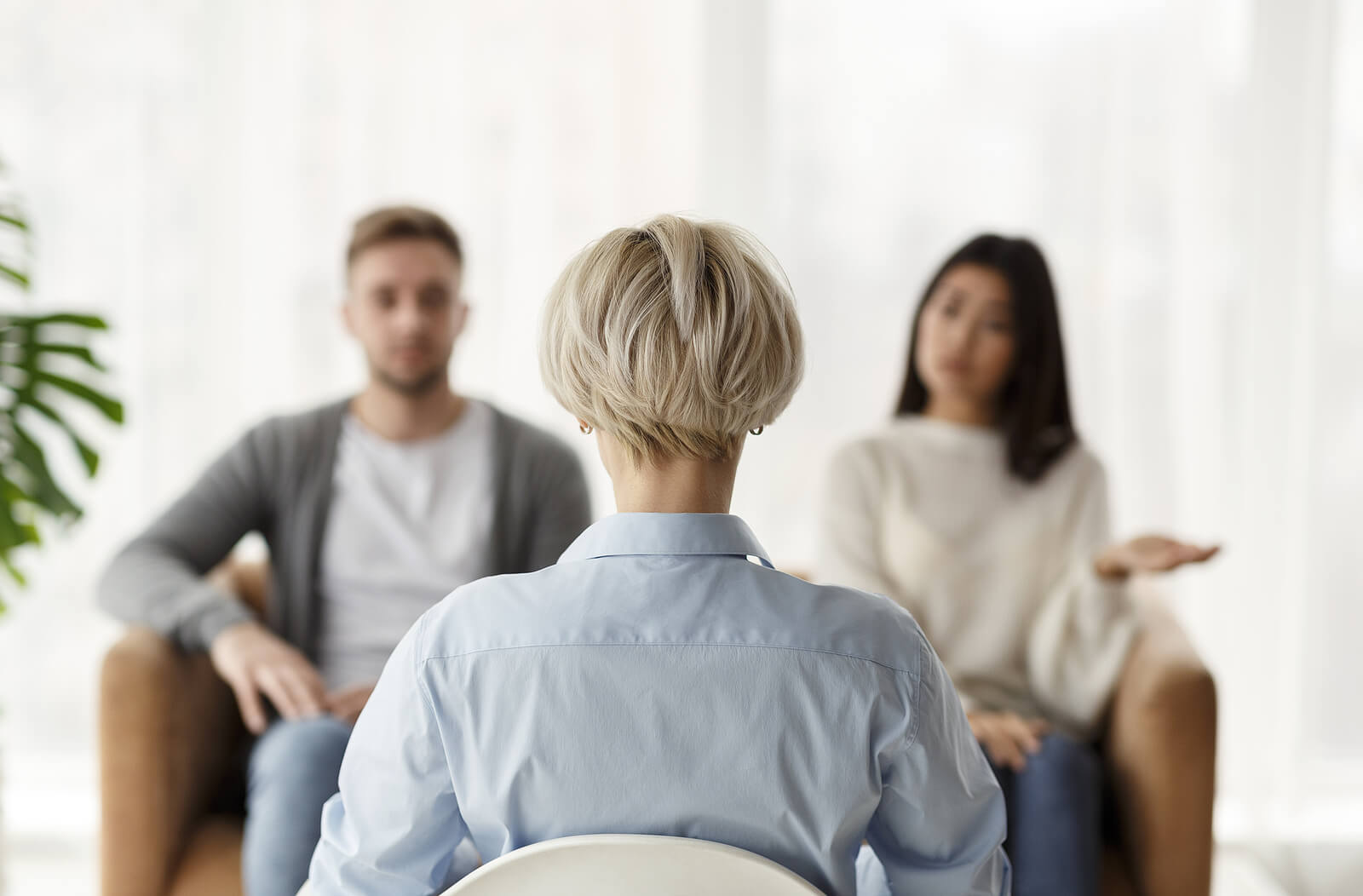 A woman sits in a chair across from  a couple. This could represent a codependency therapist in Tigard, OR working to support a couple overcome toxic bonds. Search for online therapy for codependency to learn more about codependency treatment and other services. 
